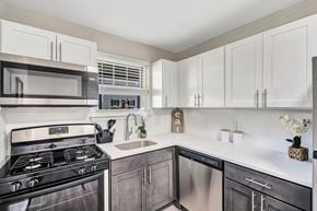 Marlton apartment for rent - A modern kitchen with a stainless steel oven and white cabinets.