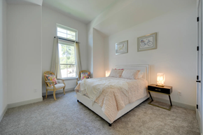 Spring Branch house for rent - A bedroom with a large bed and a chair by the window.