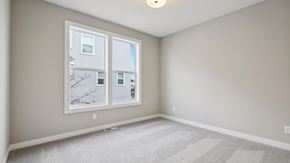 Hugo house for rent - A room with a carpeted floor and a window showing a tree and a building outside.