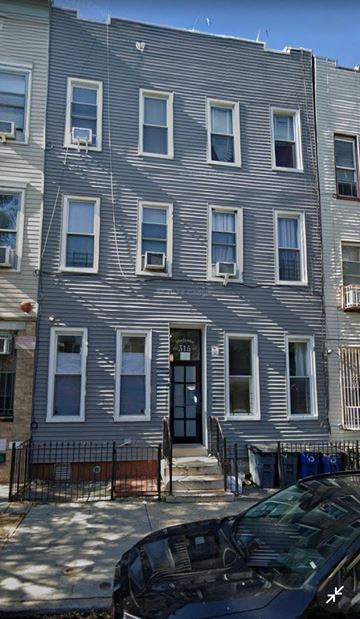 Brooklyn apartment for rent - A grey building with a black car parked in front.