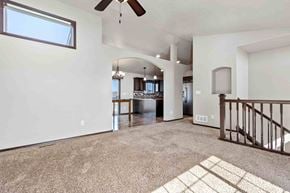 Sioux Falls house for rent - A spacious living room with a ceiling fan and a large window.