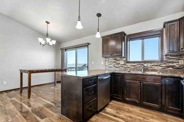Sioux Falls house for rent - A kitchen with dark wood cabinets and a granite countertop.