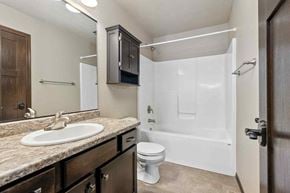 Sioux Falls house for rent - A bathroom with a sink, toilet, and bathtub.