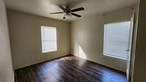 Killeen apartment for rent - A room with a ceiling fan and two windows.
