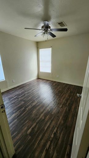 Killeen apartment for rent - A room with a ceiling fan and wooden flooring.