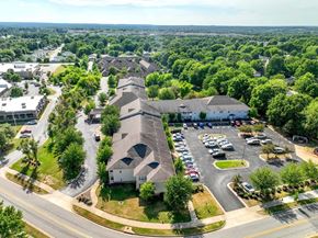 Fayetteville apartment for rent - A large white building with a parking lot in front of it.