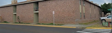 Monahans apartment for rent - A building with a brick wall and a white car parked in front.