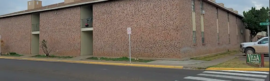 Monahans apartment for rent - A building with a brick wall and a white car parked in front.