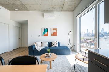 Chicago apartment for rent - A living room with a blue couch and a painting on the wall.