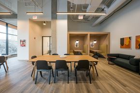 Chicago apartment for rent - A conference room with a long table and chairs, and two exit signs above it.