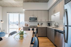 Chicago apartment for rent - A modern kitchen with a wooden table and stainless steel appliances.