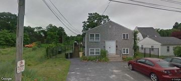 Johnston apartment for rent - A grey house with a red car parked in front.