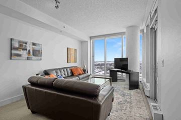 Calgary apartment for rent - A living room with a brown couch and a flat screen TV.