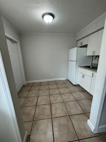 Fort Myers apartment for rent - A kitchen with white cabinets and a tiled floor.