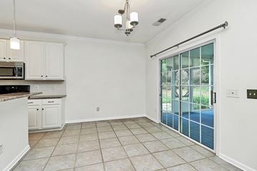 Waxhaw house for rent - A kitchen with white cabinets and a microwave.