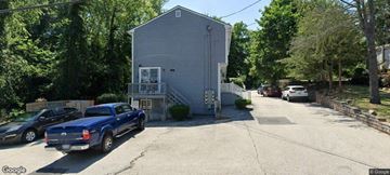 Warwick apartment for rent - A blue truck is parked in front of a two-story house.