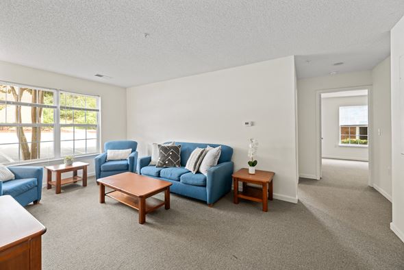 Farmville apartment for rent - A living room with a blue couch and a coffee table.