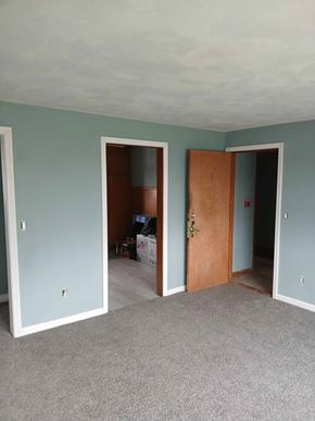 Johnston apartment for rent - A room with a carpeted floor and a brown door.