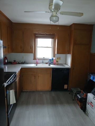 Johnston apartment for rent - A kitchen with wooden cabinets and a black fridge.