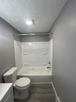 Dayton apartment for rent - A white toilet sits next to a walk-in shower in a small bathroom.