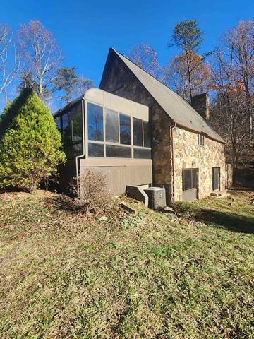 Johnson City house for rent - A small stone house with a triangular roof and a large window.