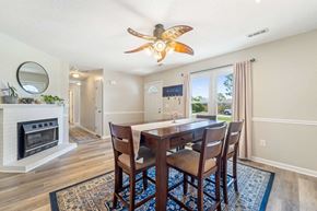Hubert house for rent - A dining room with a fireplace and a fan.
