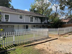 Nacogdoches apartment for rent - A house with a grey roof and white picket fence.