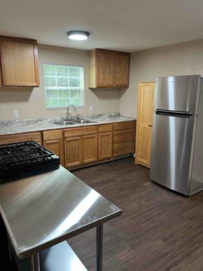 Nacogdoches apartment for rent - A kitchen with a stainless steel refrigerator and wooden cabinets.