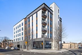 Newark apartment for rent - A modern multi-story building with a white and brown facade and a grey base.