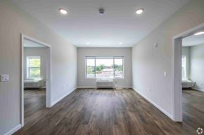 Newark apartment for rent - A spacious room with wooden floors and a large window.