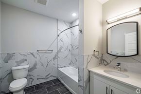 Newark apartment for rent - A bathroom with a marble patterned floor and walls.