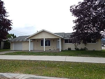 Hayden house for rent - A beige house with a white garage door and a grey roof.