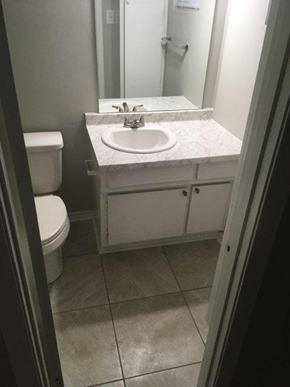 Nacogdoches apartment for rent - A white bathroom with a toilet, sink and mirror.