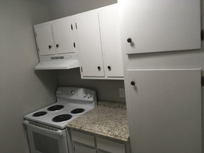 Nacogdoches apartment for rent - A white kitchen with a stove and cabinets.