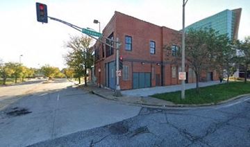 St. Louis apartment for rent - A red brick building is situated at a street corner with a traffic light.