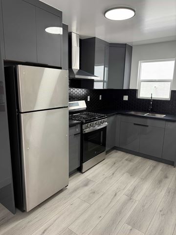 Los Angeles apartment for rent - A modern kitchen with a refrigerator, sink, and cabinets.