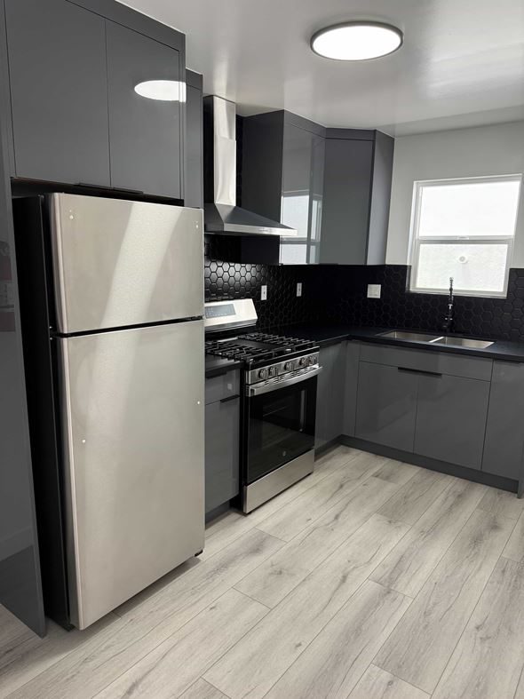 Los Angeles apartment for rent - A modern kitchen with a refrigerator, sink, and cabinets.