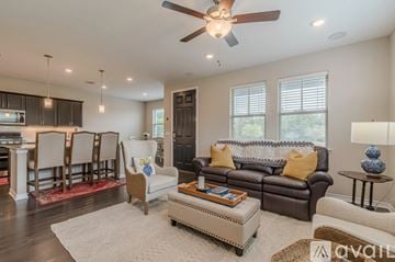 San Marcos condo for rent - A living room with a brown leather couch and a white chair.