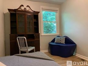 Nashville apartment for rent - A room with a bed, a chair, a cabinet, and a bean bag chair.