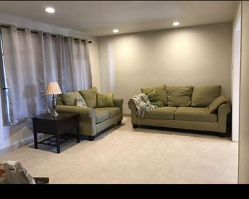 Reno house for rent - A living room with two couches and a table with a lamp on it.