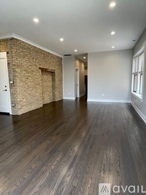 Chicago apartment for rent - A room with wooden flooring and a brick wall.