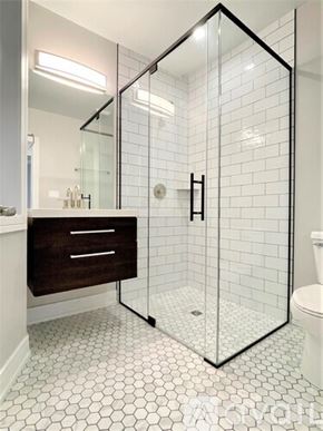 Chicago apartment for rent - A white tiled bathroom with a walk in shower.