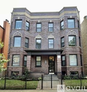 Chicago apartment for rent - A large brick building with a black gate in front.