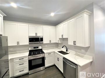Chicago apartment for rent - A kitchen with white cabinets and appliances.