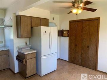Middleton house for rent - A kitchen with a white refrigerator and wooden cabinets.