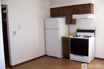 Pekin house for rent - A kitchen with a white refrigerator and a black stove top oven.