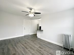 Chicago apartment for rent - A spacious room with a ceiling fan and a radiator on the wall.