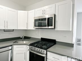 Chicago apartment for rent - A kitchen with white cabinets and a black stove top.