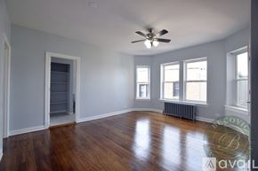 Chicago apartment for rent - A room with a ceiling fan and wooden floors.