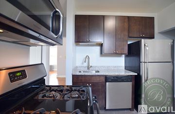 Chicago apartment for rent - A modern kitchen with a stove top oven and a refrigerator.